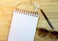 Notebook,earphone,pen,sunglasseses on wood background