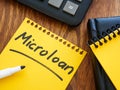 Notebook with entry about microloan and calculator. Royalty Free Stock Photo