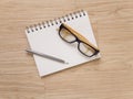 Notebook eye glasses and pencil on wood floor