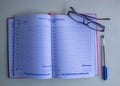 A notebook, eyeglasses and a blue pen. Royalty Free Stock Photo