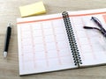 Notebook, eyeglasses, pen and yellow blank sticky notes on wooden table floor Royalty Free Stock Photo