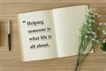 Notebook with flower on wood background with quote Royalty Free Stock Photo