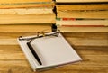 Notebook with fountain pen,glasses and books on wooden desk Royalty Free Stock Photo