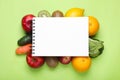 Notebook, fresh fruits and vegetables on light green background, flat lay. Low glycemic index diet Royalty Free Stock Photo