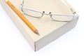 Notebook glasses and yellow pencil on box