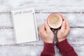 Notebook with goals for 2018 and male hand with cup of coffee. Planning and motivation for the new year concept. Top view. Royalty Free Stock Photo