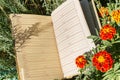 Notebook on green grass with flowers