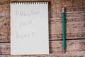 Notebook and green pencil, Follow your heart. Motivational phrases and quotations, success in life and business, achievement of