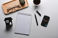 Notebook, house model and calculator on white background. Real estate investment.