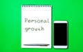 Notebook with the inscription Personal growth, a pen and a telephone. Self-improvement of skills, knowledge, personal qualities