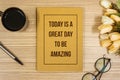 Notebook with Inspirational Quote on Wooden Work Desk. Be Amazing