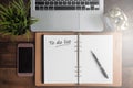 Notebook, laptop, clock, smartphone and journal on a wooden table with TO DO LIST word