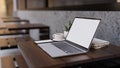 Notebook laptop mockup on wood table in modern coffee shop Royalty Free Stock Photo
