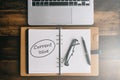 Notebook, laptop, pen and spectacles on a wooden table with CURRENT ISSUES word