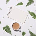 Notebook leaf and flower on table morning concept. Royalty Free Stock Photo