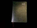 Notebook - a leather-bound diary, on a black background. Notebook for time planning Royalty Free Stock Photo