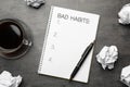 Notebook with list of bad habits, pen, crumpled paper balls and cup of coffee on grey table, flat lay. Change your lifestyle Royalty Free Stock Photo