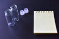 Notebook and medicine bottles on a black background