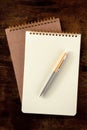 Notebook mockup with a pen, top shot on a wooden desk Royalty Free Stock Photo