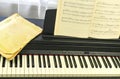 Notebook with musical scores placed on sleek electronic piano, highlighting preparation Royalty Free Stock Photo