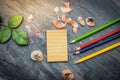 A notebook for notes with crayons and pencils. Pencil sharpener placed on a table made of stone. Using image for education with b Royalty Free Stock Photo