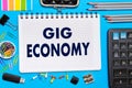 Notebook with Notes GIG ECONOMY office tools on a blue background . Concept GIG ECONOMY Royalty Free Stock Photo