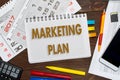 Notebook with a notes MARKETING PLAN on the office table with tools Royalty Free Stock Photo