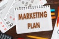 Notebook with a notes MARKETING PLAN on the office table with t Royalty Free Stock Photo