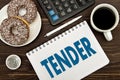 Notebook with a notes TENDER on the office table with coffee and donuts . Concept TENDER. Royalty Free Stock Photo