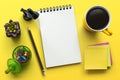 Notebook on office table with a cup of coffee, plant, stationery and office supplies. Blank notepad paper for input copy or text. Royalty Free Stock Photo