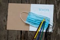 Notebook open in a ruler colored pencils and a medical mask on the school desk, home education Royalty Free Stock Photo