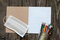 Notebook open in a ruler colored pencils and a medical mask on the school desk, home education Royalty Free Stock Photo