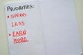 Notebook page, with text `priorities: spend less, earn more` Royalty Free Stock Photo