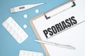 Notebook page with text PSORIASIS on a table with a pills and pencil, medical concept, top view Royalty Free Stock Photo