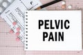 Notebook page with words - Pelvic Pain nearby with a pills and pencil, medical concept