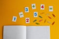 Notebook, paper clips, numbers on a yellow background. Accessories for study. Mathematics, geometry, algebra