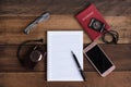 Notebook, passport, camera, compass and smarphone on a wooden table