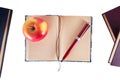 Notebook with pen and apple