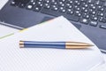 Notebook and pen on the black keyboard. Close up. Royalty Free Stock Photo