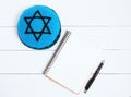 Notebook, pen and blue kipa on a white wooden background, top view. Jewish New Year, Rosh Hashanah