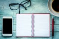 Notebook,pen,cellphone, glasses and coffee on wooden table Royalty Free Stock Photo