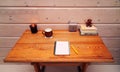 Notebook, pen, coffee, candlestick, books, clock and teddy bear on a wooden table.