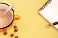 Notebook with pen and cup of cocoa on bright background