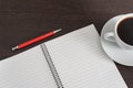 Notebook with pen and cup of coffee on brown wooden table