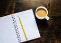 Notebook pen and cup of coffee in wood table Royalty Free Stock Photo