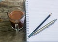 Notebook pen and cup of coffee in wood table Royalty Free Stock Photo