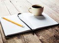 Notebook pen and cup of coffee in wood table Royalty Free Stock Photo
