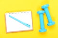 Notebook, pen and gym equipment top view on yellow background Royalty Free Stock Photo