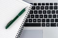 Notebook and pen on the laptop keyboard, close up Royalty Free Stock Photo