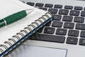 Notebook and pen on the laptop keyboard, close up Royalty Free Stock Photo